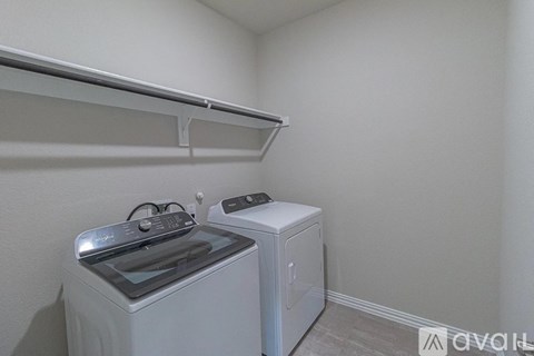 A small laundry room with a washer and dryer.