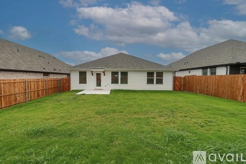 A house with a white front yard and a brown fence.