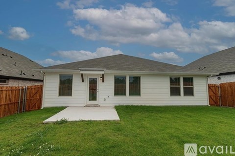 A house with a brown fence and a white front door.