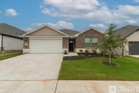 A house with a garage and a tree in front.