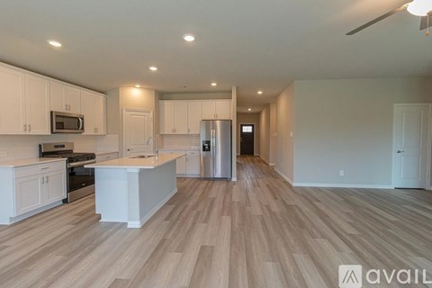 A kitchen with white cabinets and a wooden floor.