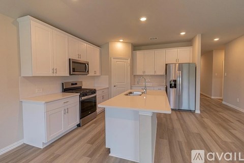 A kitchen with white cabinets and a wooden island.