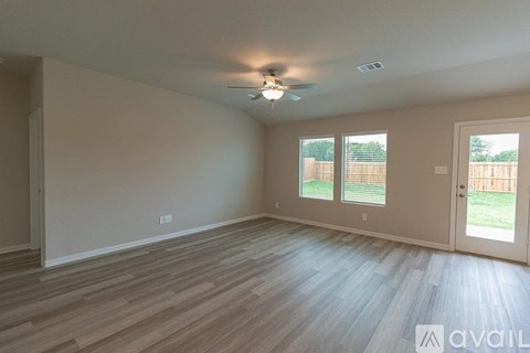 A room with a ceiling fan and sliding glass doors.