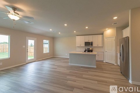 A spacious kitchen with a refrigerator, microwave, and oven.