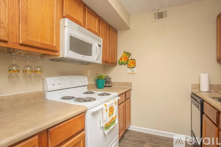A kitchen with a white stove top oven and a white microwave above it.