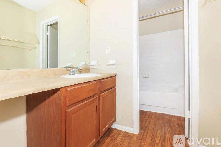 A bathroom with a wooden vanity and a white bathtub.