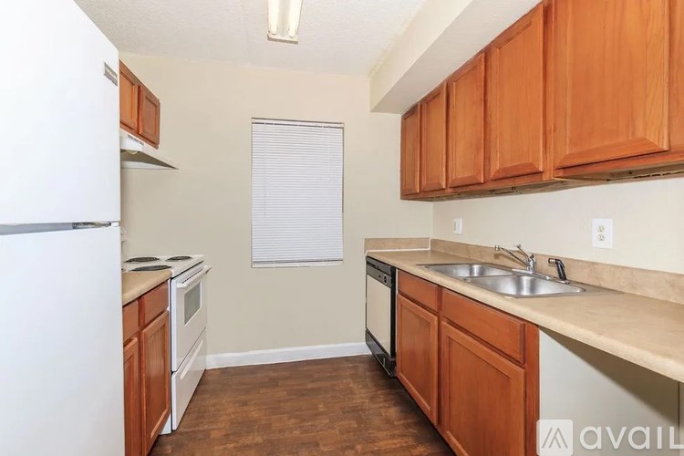 A kitchen with wooden cabinets and a white refrigerator.