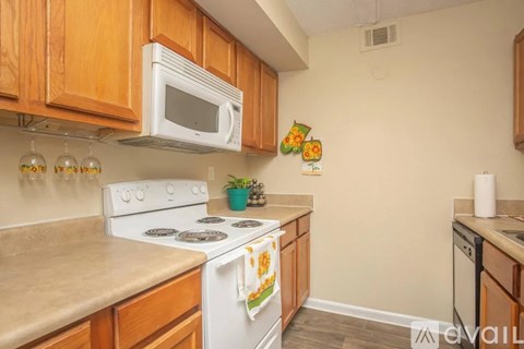 A kitchen with a white stove top oven and a white microwave above it.