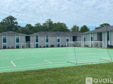 A tennis court with a green surface and a white net.