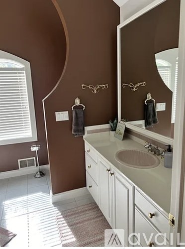 A bathroom with brown walls and a white sink.