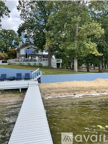 A wooden walkway leads to a house with a pool in the foreground.