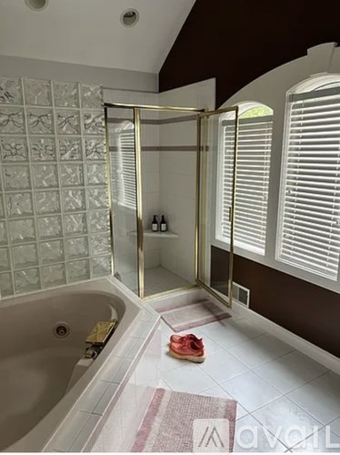 A bathroom with a white tub and a glass shower stall.