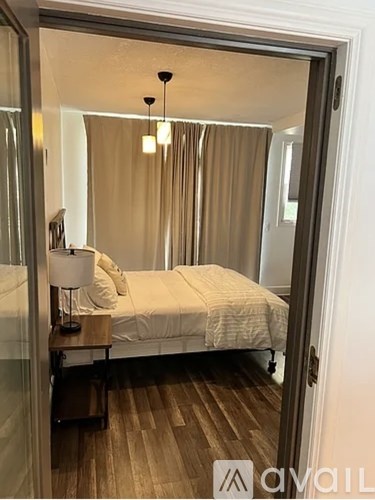 A bedroom with a bed, nightstand, and lamp.