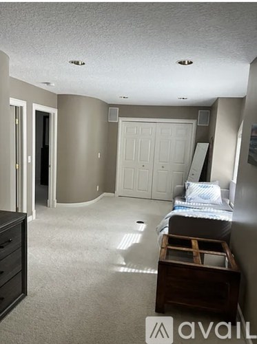 A bedroom with a bed, dresser, and wardrobe.