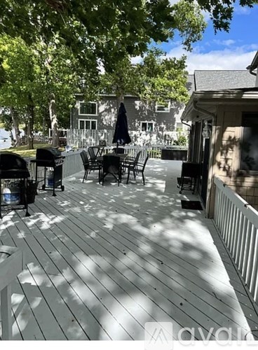A wooden deck with chairs and a table.