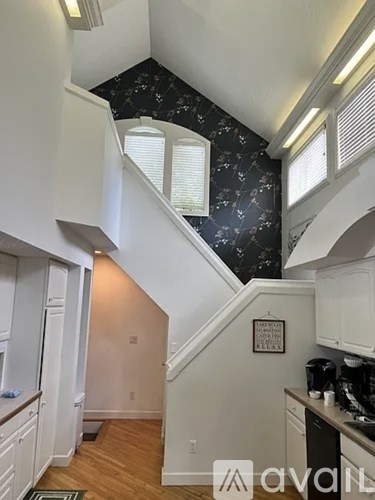 A kitchen with a staircase leading to the upper floor.