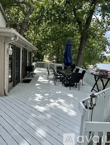 A deck with a table and chairs overlooking a body of water.
