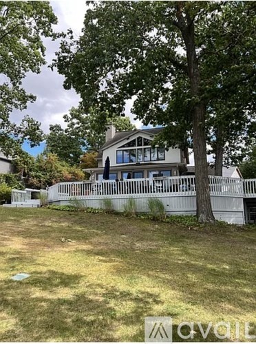 A house with a white fence and a tree in front.