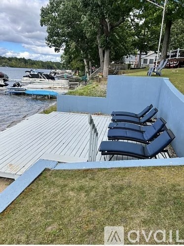 A patio with chairs and a view of a lake.