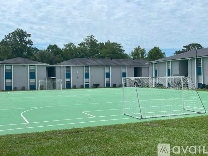 A tennis court with a green surface and a white net.