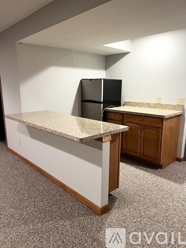 A kitchen with a granite countertop and a black refrigerator.