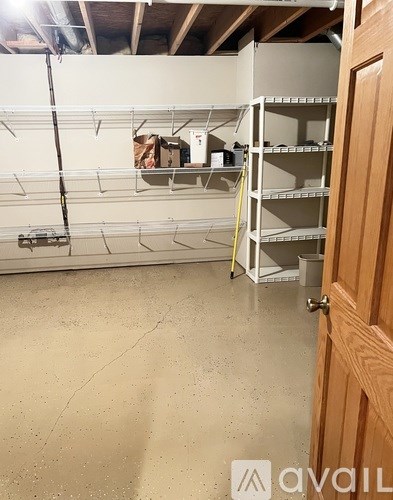 A room with a wooden door and a wall of shelves.