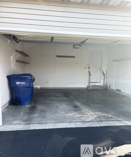 Garage with a blue bin and a white door.