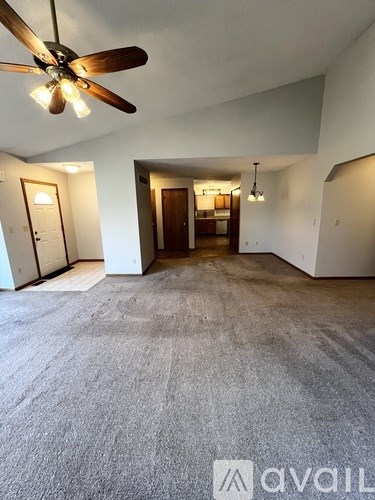 A room with a ceiling fan and carpeted floor.