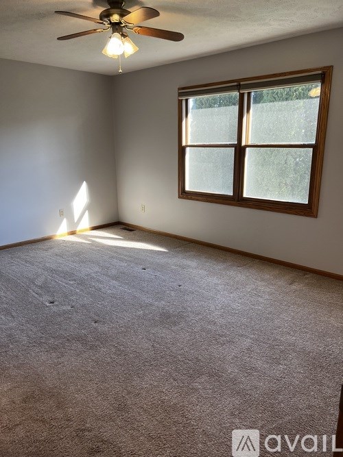 A room with a ceiling fan and a window.