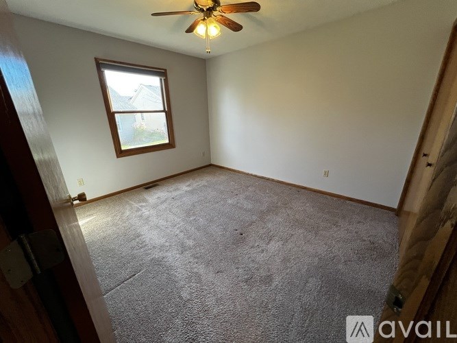 A room with a ceiling fan and a window.