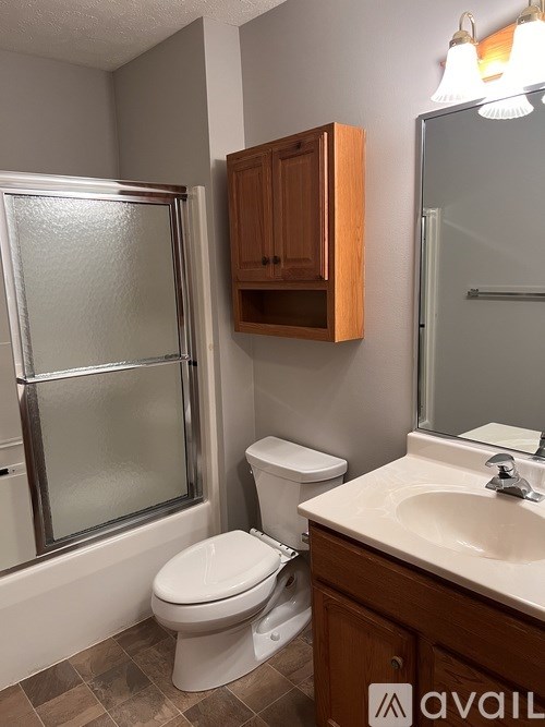 A bathroom with a toilet, sink, and shower.