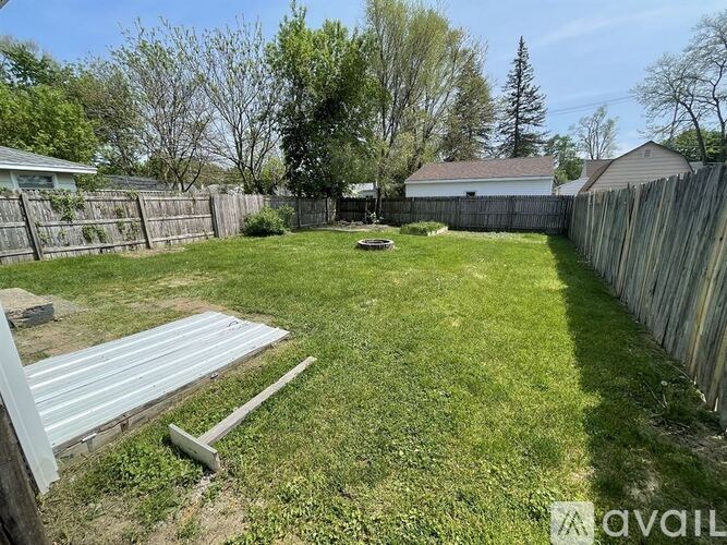 A backyard with a metal structure and a wooden fence.