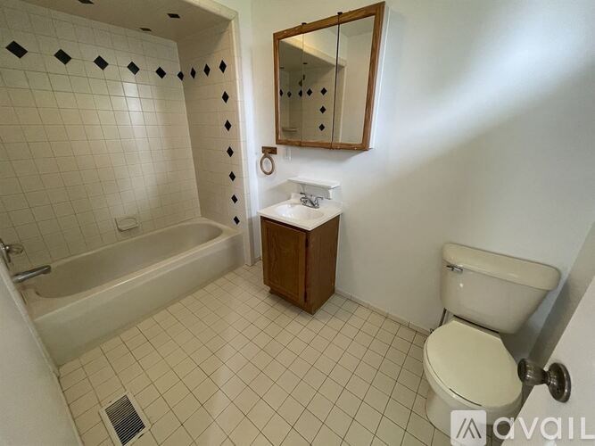 A bathroom with a white toilet, a white sink, and a bathtub.