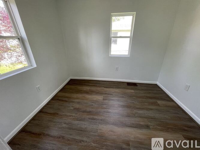 A room with wooden flooring and a window.