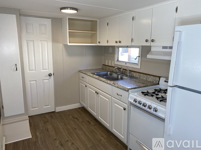 A kitchen with white cabinets and a white refrigerator.