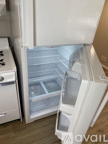 A white refrigerator with its door open and shelves visible.