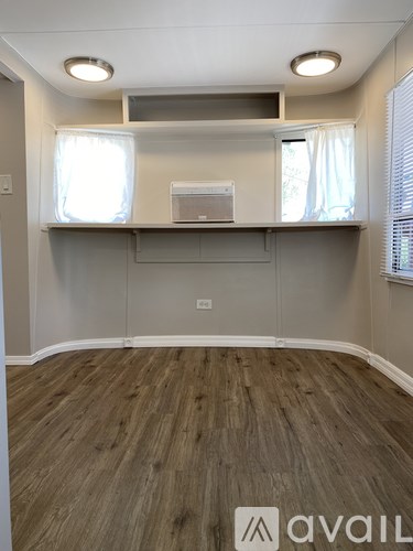A room with wooden flooring and a wall-mounted shelf.