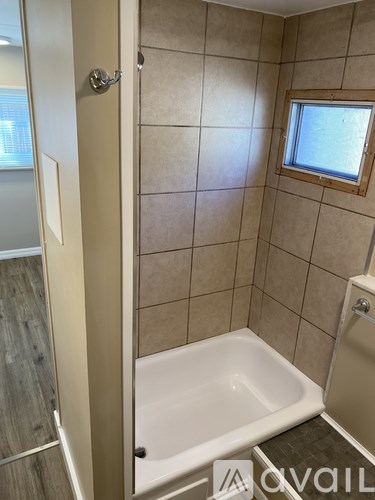 A bathroom with a tub and a window.