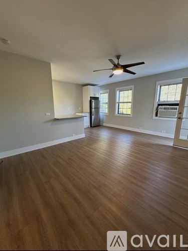 A room with wooden flooring and a ceiling fan.