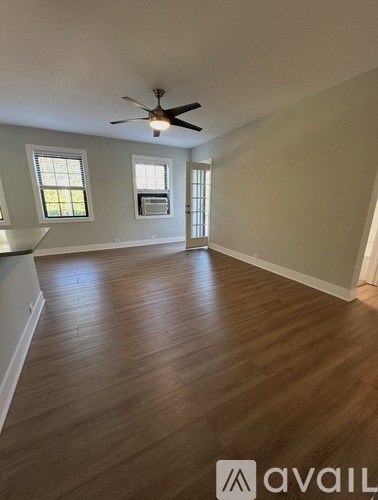 A room with wooden flooring and a ceiling fan.