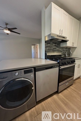 A modern kitchen with a washer and dryer built in.