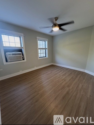 A room with wooden flooring and a ceiling fan.