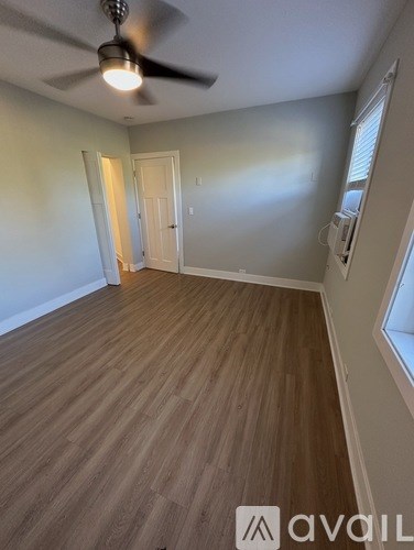 A room with wooden flooring and a ceiling fan.