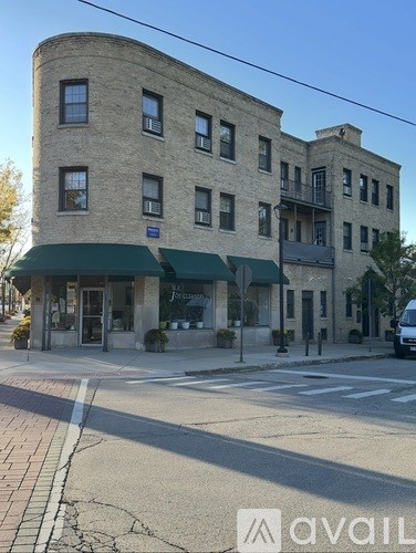 A building with a green awning is in front of a street.