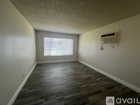 A room with a window and a wall-mounted air conditioner unit.