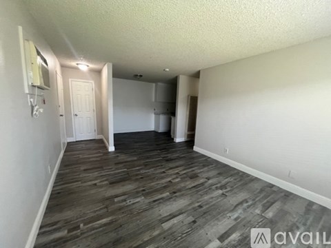 A room with wooden flooring and white walls.