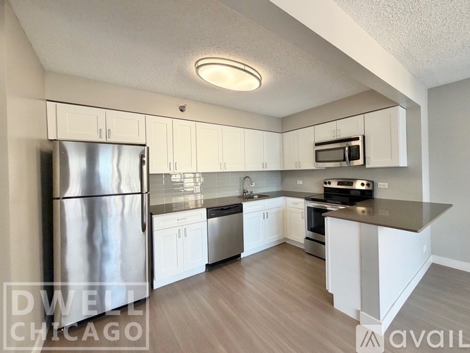 A kitchen with white cabinets and a stainless steel refrigerator.