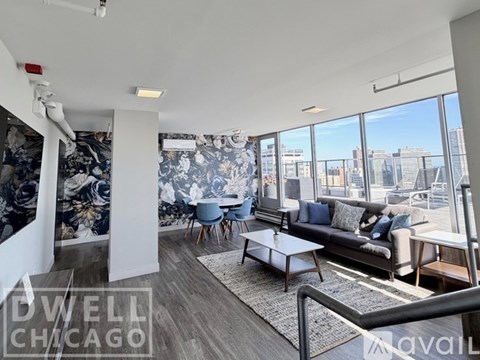 A living room with a couch, chairs, and a coffee table with a view of the city.