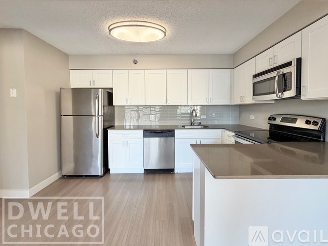 A kitchen with a refrigerator, microwave, and oven.