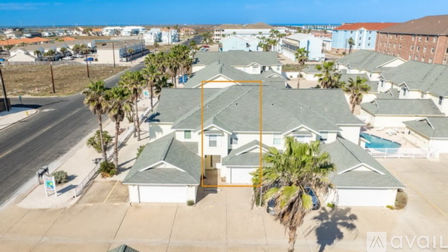 A bird's eye view of a residential area with houses and palm trees.